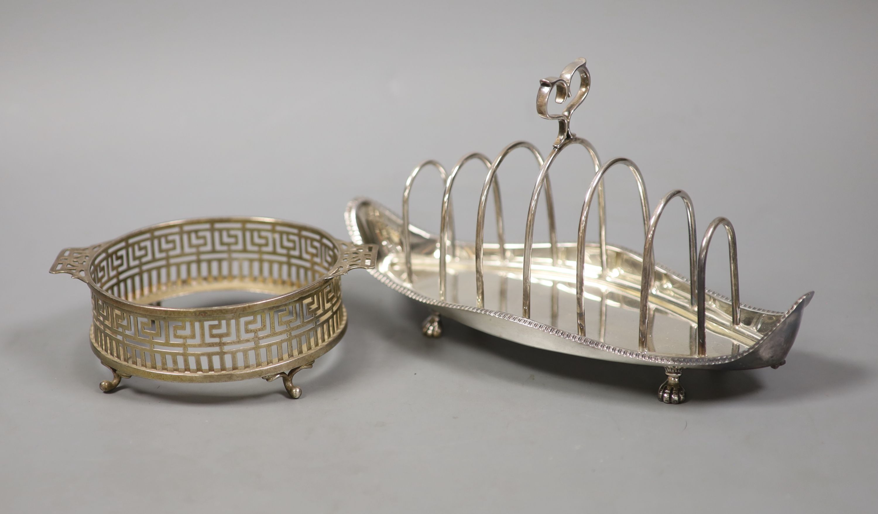 A late Victorian silver seven bar toastrack, with shaped ring handle, on paw feet, Josiah Williams & Co, London, 1896?, 21.2cm and a silver dish, lacking glass liner